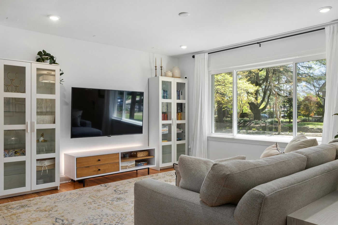 Bright living room with a large flat-screen TV wall mounted above a low media unit